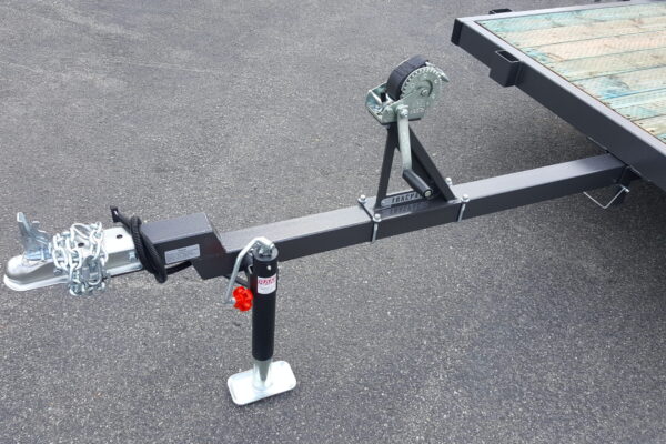 A trailer with a black and silver pole on the ground