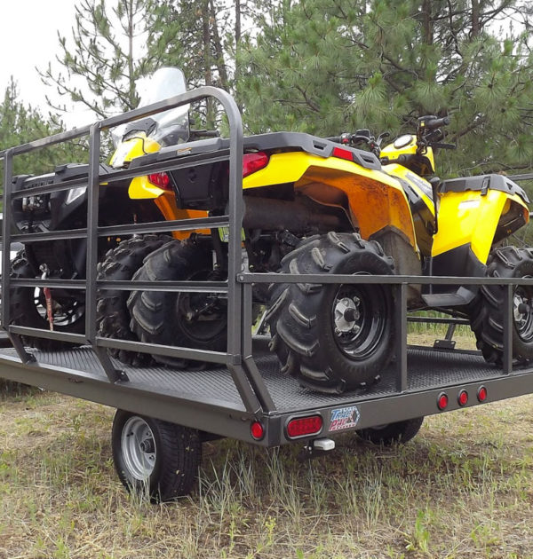 A yellow and black atv is parked on the trailer.