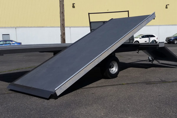 A flat bed trailer with a ramp on the back.