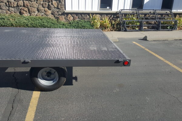 A flat bed trailer with a large metal deck.